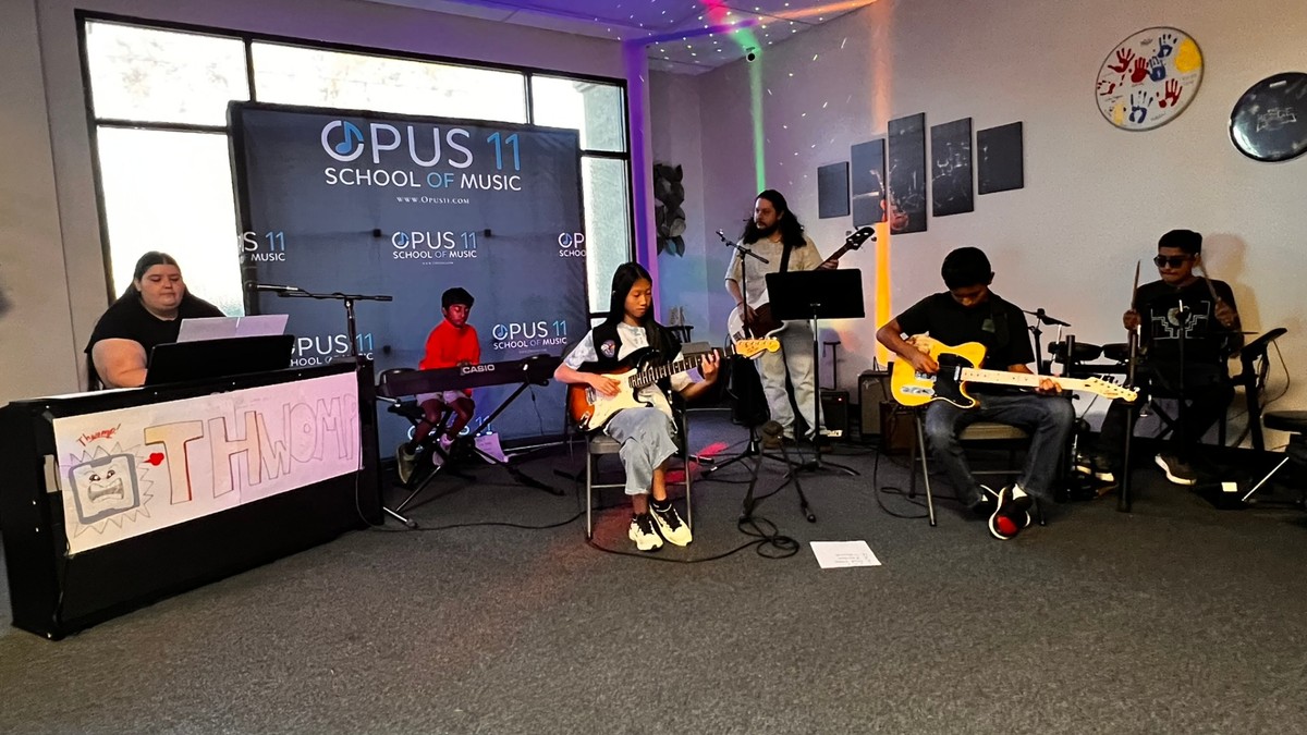 Headliners student band performing live with keyboards, guitars, and drums